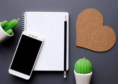 Office desk table with blank notepad, smartphone and cacti Foto stock