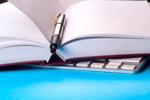 Office desk table with computer, books, a magnifying glass and pen. Stock Photos