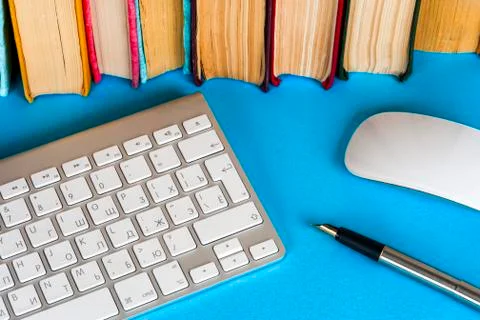 Office desk table with computer, books, a magnifying glass and pen. Stock Photos
