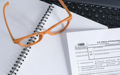 Office desk table with computer, eyegglass 1065 taxform on notebook Stock Photos