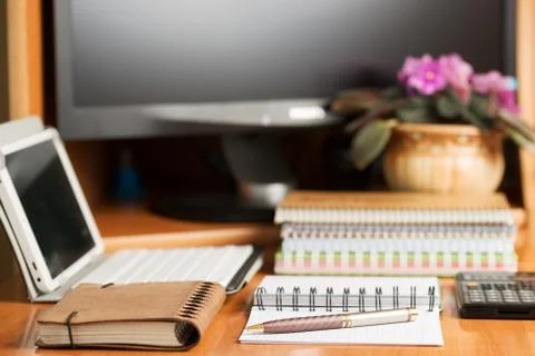 Office desk table with computer, supplies, flower Foto stock