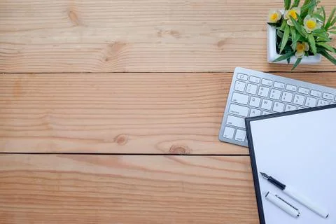 Office desk table with keyboard, notebook, pen, cup of coffee and flower. Top Foto stock