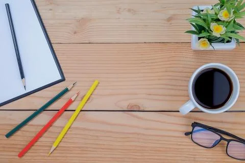 Office desk table with keyboard, notebook, pen, cup of coffee and flower. Top Foto stock