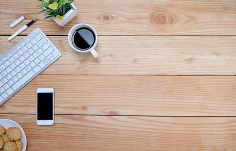 Office desk table with keyboard, notebook, pen, cup of coffee and flower. Top Foto stock