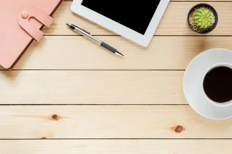 Office desk table with tablet, coffee cup ,pen and notebook.Top view with cop Stock Photos