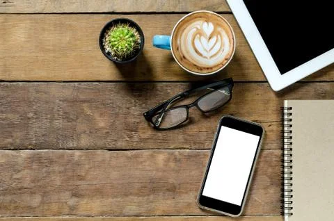 Office desk table with tablet, coffee cup ,smartphone and notebook.Top view w Stock Photos