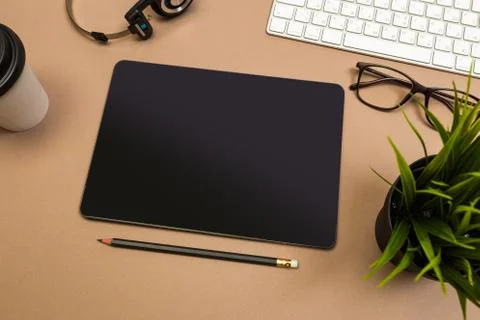 Office desk table with  tablet  keyboard headphones coffee and glasses Mock u Stock Photos