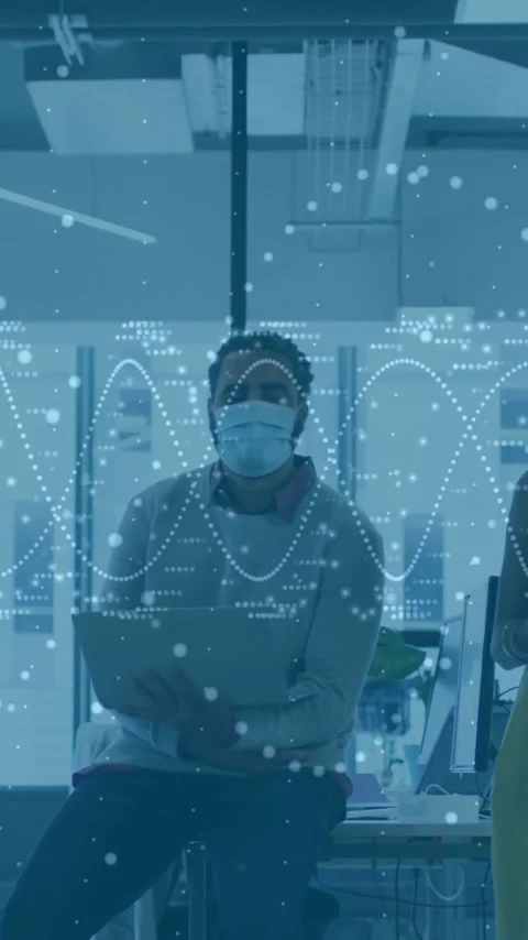 In office, diverse team collaborating with data animation overlay wearing masks Stock Footage 319617992