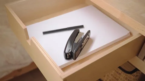Office drawer with stapler and pen on white paper Stock Footage 343710058