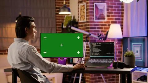 Office employee analyzing greenscreen on computer monitor 스톡 사진