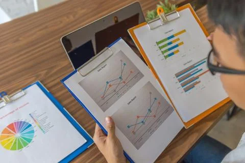 Office employee checking the data on sales reports in office Foto stock