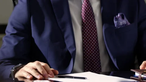 Office employee sits near table and shares meeting details Stock Footage 244910686