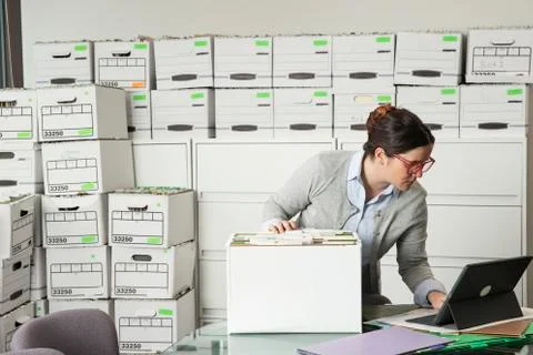 Office employee sorting through boxes and checking tablet., Jacksonville, Stock Photos