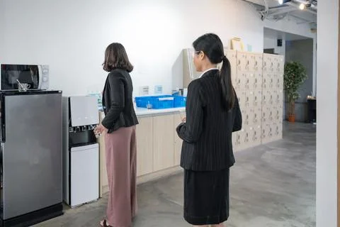 Office employee standing in queue up to drink water form water dispenser Stock Photos
