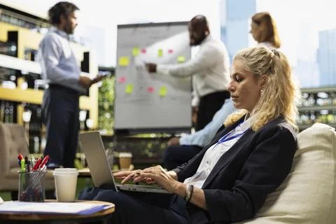 Office employee taking notes on laptop during outdoor planning meeting Stock Photos