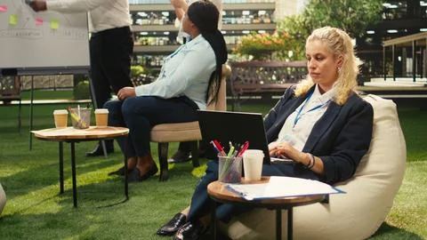 Office employee taking notes on laptop during outdoor planning work Stock Photos