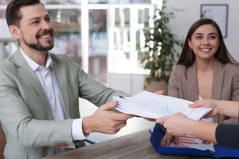Office employees working with documents at table indoors Stock Photos