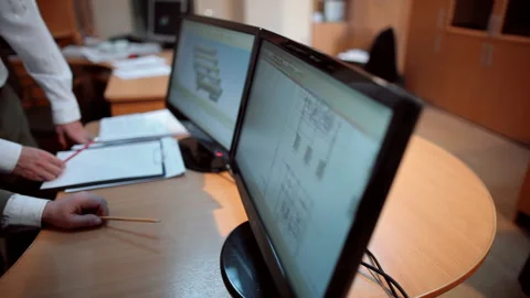 In the office engineers review and discuss the details in the diagrams Stock Footage 92199565