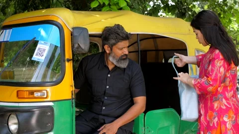 An office girl getting down from auto-rickshaw - paying fare to driver, daily... Stock Footage 260802663