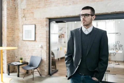 Office guy with grey jacket posing with hands in the pockets Stock Photos