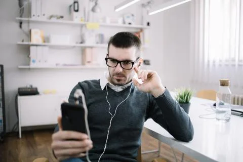 Office guy using phone and listening music in office Foto stock