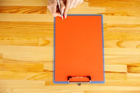 Office Hand Holding a Folder with a Red Color Paper on the Background of the Foto stock