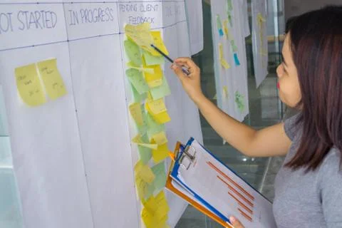 Office lady checking data in chart with information on sticky note Stock Photos