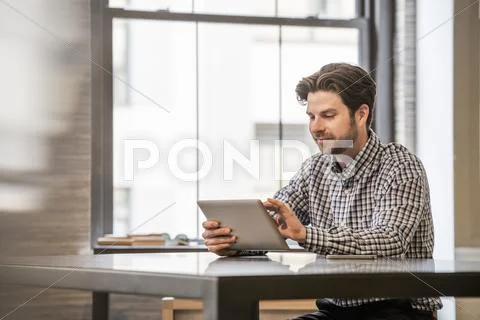 Office life. a man working on a digital tablet at an office desk. Stock-Fotos