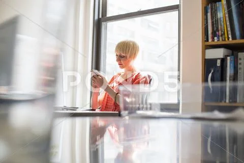 Office life. a young woman checking her cell phone. Stock-Fotos