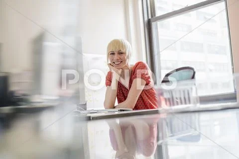 Office life. a young woman sitting at an office desk, her chin resting on her Stock-Fotos