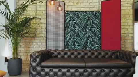 Office in loft style, leather pattern of a black luxury sofa, potted palm tree 스톡 동영상 267202581