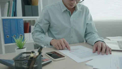 Office man checks documents and calculat... | Stock Video | Pond5