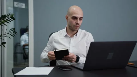 Office man look through notes written in book and typing in laptop 스톡 동영상 159558707