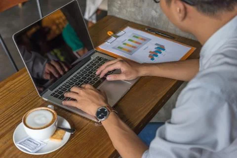 Office man reading financial data on report and using laptop Stock Photos