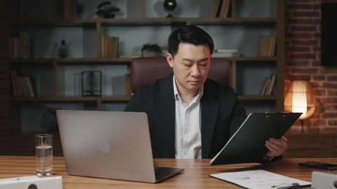Office manager comparing electronic and paper contract Stock Footage 245724347