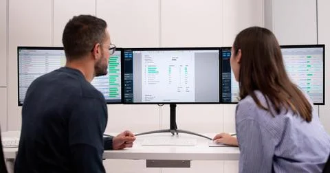 Office Manager Creating Spreadsheet Invoicing Report On Desktop Computer Foto stock