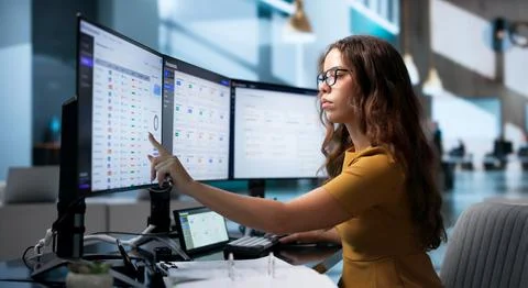 Office Manager Efficiently Organizing Files On Touchscreen Monitor At Work. Stock Photos