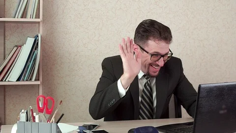 Office Manager man with beard and glasses talking via video link in laptop. Видео 100404189