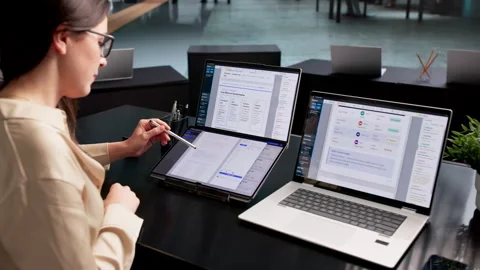 Office Manager Organizing Digital Documents On Dual Touchscreen Laptop Stock Footage 339907725