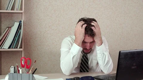 The office Manager was man, a bad headache. He was tired of long work Stockbeeldmateriaal 100422782