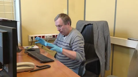 Office Manager willfully enjoys wearing medical gloves and clicks on keyboard Stock Footage 130510147