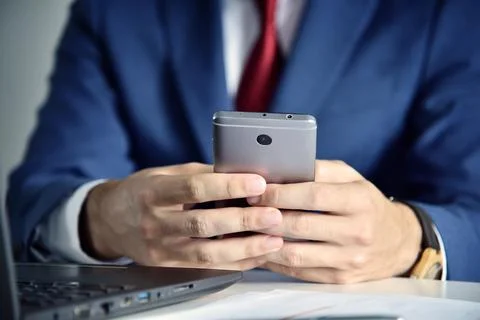 Office manager writes message on mobile phone. Stock Photos