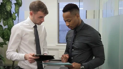 In office multi-ethnic man tells a colleague about a profitable investment Stock Footage 85375040