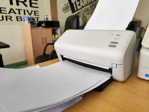Office printer printing documents on desk in modern workspace setting 스톡 사진
