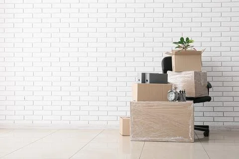 Office relocation and moving boxes with desk chair, business transition and n Stock Photos