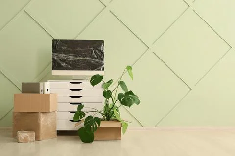 Office setup with computer, cardboard boxes, and plant Stock Photos