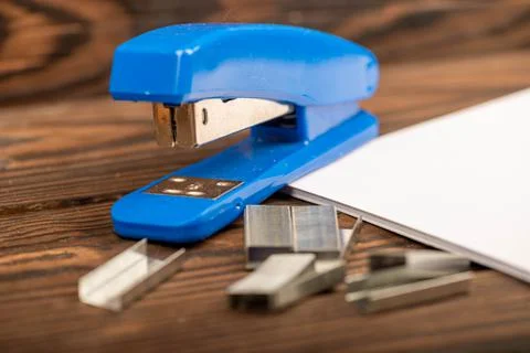 Office stapler, stapler staples and white paper on the table, close-up, selec Stock Photos