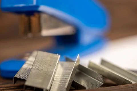 Office stapler, stapler staples and white paper on the table, close-up, selec Stock Photos