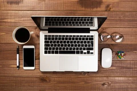 Office stuff with notepad, laptop and coffee cup mouse notepad top view shot. Stock Photos