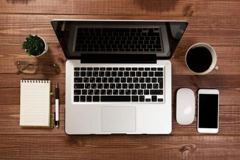 Office stuff with notepad, laptop and coffee cup mouse notepad top view shot. Stock Photos